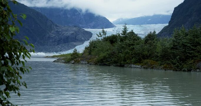 Mendenhall Glacier peeks out from outcropping under overcast sky
