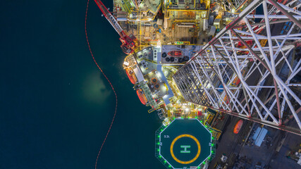 Aerial view jack up rig under maintenance at night, Aerial view of jack up rig with towing vessel...