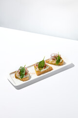 Aesthetic composition with tomato bruschetta on white background with harsh shadows. Italian bruschetta with tomatoes and cheese on fine dining in summer. Elegant menu concept.