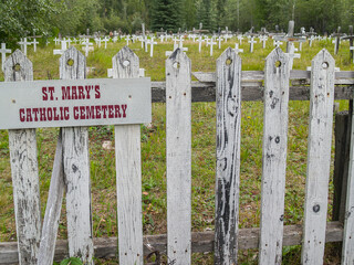St Mary's Catholic Cemetery, a field of grave and crosses with weathered white picket fence