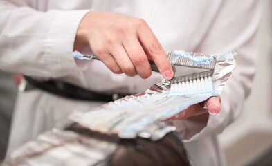 Hairdresser stylist takes care of girl's hair. Hair care procedures in a beauty salon. Hair...