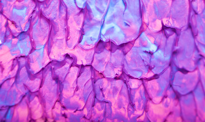 Obraz premium Beautiful abstract background with spots of blue, pink, green, yellow and purple paint. Oil paint, flowing down the canvas, shimmers with galagrophic paints with neon illumination.