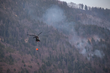 Fototapeta na wymiar Wildfire smoldering on the mountain range, burning forest