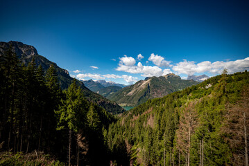 Obraz premium landscape with clouds over the mountains dolomiti monte Pelmo, with blue sky and green trees in Italy
