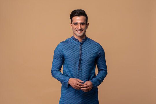 Young handsome Indian man wearing kurta with gifts in hand