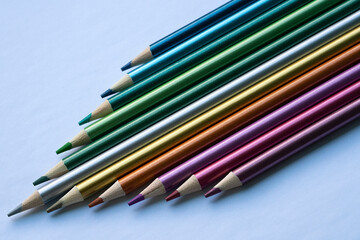 Fototapeta premium Colored pencils with a metallic sheen close-up. Background with place for text. High quality photo