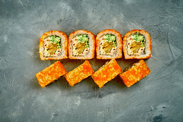 Sushi roll with eel and cucumber on gray background. Selective focus, noise added in post-production