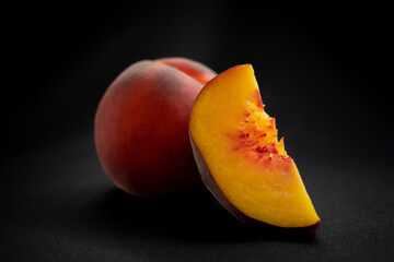 peach with a piece of peach on a dark background