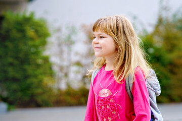 Cute little preschool girl o the way to school Healthy happy child walking to nursery school and kindergarten. Smiling child with backpack on the city street, outdoors. Back to school.
