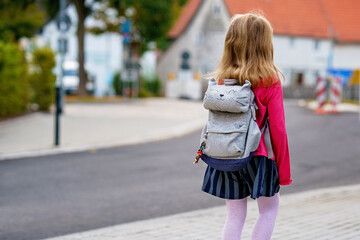 Cute little preschool girl o the way to school Healthy happy child walking to nursery school and kindergarten. Smiling child with backpack on the city street, outdoors. Back to school.