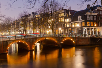 Fototapeta na wymiar Nightscape along the canal and bridges in Amsterdam during winter : Amsterdam , Netherlands : November 26 , 2019