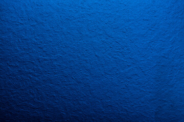 Blue background of decorative plaster with abstract spots. Unusual texture of this wall with beautiful patterns, creative surface background. Finishing coating for building cladding.