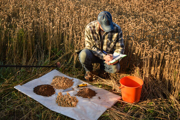 Male agronomist preparing soil samples for laboratory analysis, writing in information sheet...