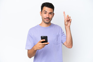 Young handsome man over isolated white background using mobile phone and lifting finger