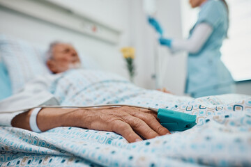 Close up of senior patient with pulse oximeter on finger in hospital.