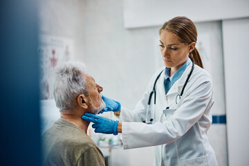 Female doctor examining senior patient at her office.
