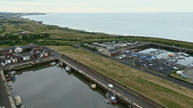Aerial Video of the small English fishing village of Maryport in Allerdale a borough of Cumbria, England.
Shot using a drone and looking down onto the harbour walls, boats, and surrounding town.