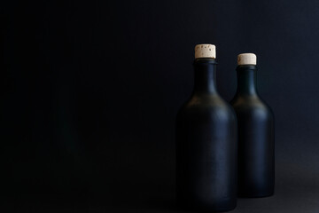 Black gin bottles, dark shot of two gin bottles with natural cork. The bottles are arranged on the right, so there is enough space for your text. Copy space for your design. Web banner. 