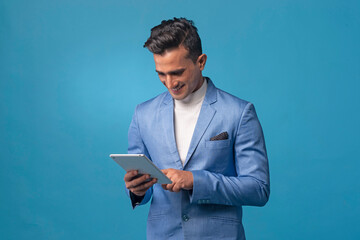 Young handsome man wearing business suit with tablet computer