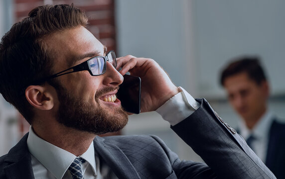 Handsome businessman speaking on mobile phone in office