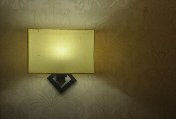 Front view of square shaped wall light lamp with textured wall