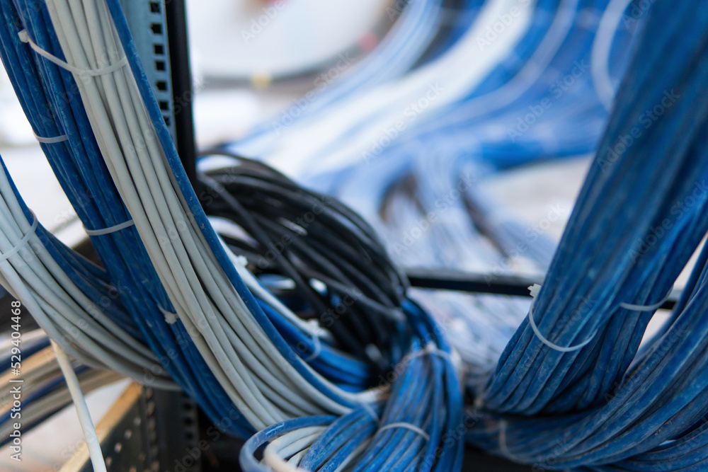 Poster a large group of utp cables, rack ethernet cables, patch panel utp cables in a server rack in a data