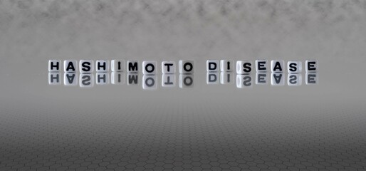 hashimoto disease word or concept represented by black and white letter cubes on a grey horizon background stretching to infinity