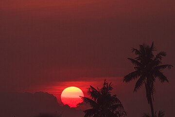 RED SUN BEHIND DARK CLOUDS