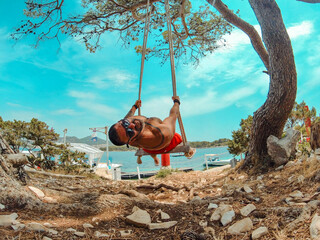hombre balanceándose en columpio