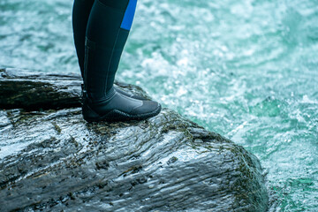 Feet in wetsuit gear ready for whitewater adventure