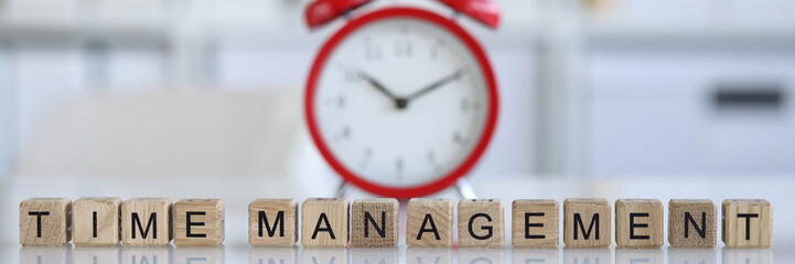 Time management and red alarm clock on table closeup
