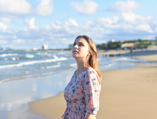 Beautiful Belarus woman walking on the beach against dramatic and romantic sky