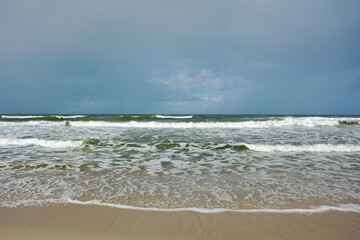 Fototapeta na wymiar Beautiful coast of the Baltic Sea in Poland. Endless sandy beach, sea water waves.