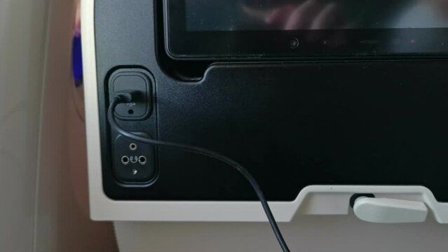 Plugging a USB device into the seat of an economy class seat