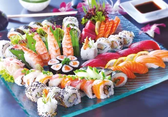 Tragetasche Big sushi set with maki, sashimi, nigiri, dragon rolls. Sushi with salmon, tuna, raw fish, on a blue, glass plate. © JacZia