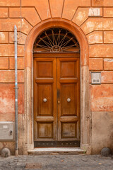 Fototapeta na wymiar Beautiful carved wooden antique vintage doors on the street in trastevere area