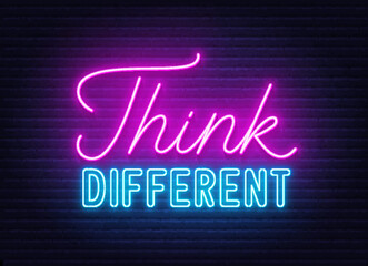 Think Different neon quote on brick wall background.