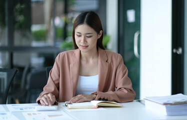 Obraz premium Business women using calculator at working with financial report.