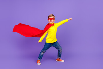 Full length photo of cute funny little grandson dressed red cape rising fist isolated purple color background