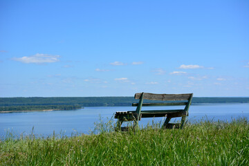 empty wooden bench on the edge of the hill with the view to volga river