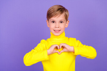 Photo of cheerful nice pupil arms fingers demonstrate heart gesture isolated on violet color background