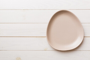 Top view of empty pink plate on wooden background. Empty space for your design