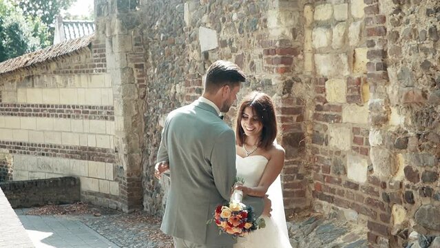 Groom pulling his bride closer to him in a beautiful alleyway in Thorn, The Netherlands.