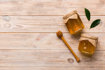 Honey jar with wooden honey dipper on white background top view with copy space. Delicious honey bottle