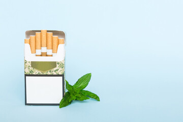 Pack of menthol cigarettes and fresh mint on colored table, Menthol cigarettes top view flat lay