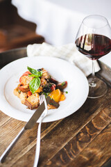 Appetizing salad with grilled vegetables and croutons on a served table.