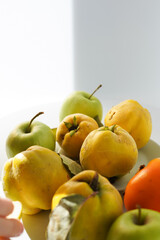  ripe quince with leaves and apples laying on a light background. minimalistic composition with autumn fruit