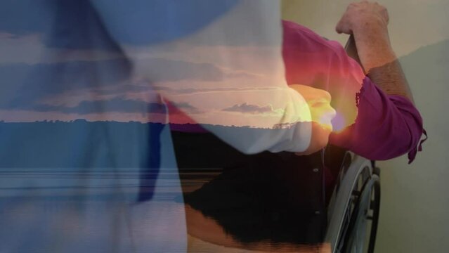 Animation of landscape over caucasian nurse with man in wheelchair