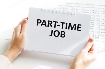 PART-TIME JOB text on a notebook in the hands of a businessman in the background of an office desk with documents