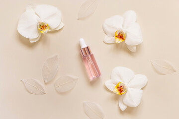 Obraz na płótnie Canvas Pink Dropper Bottle near white orchid flowers on light beige top view. Skincare beauty product